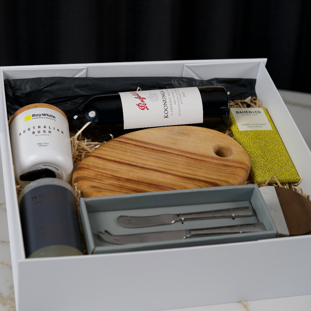 Gift set with wine, cutting board, and utensils in a box