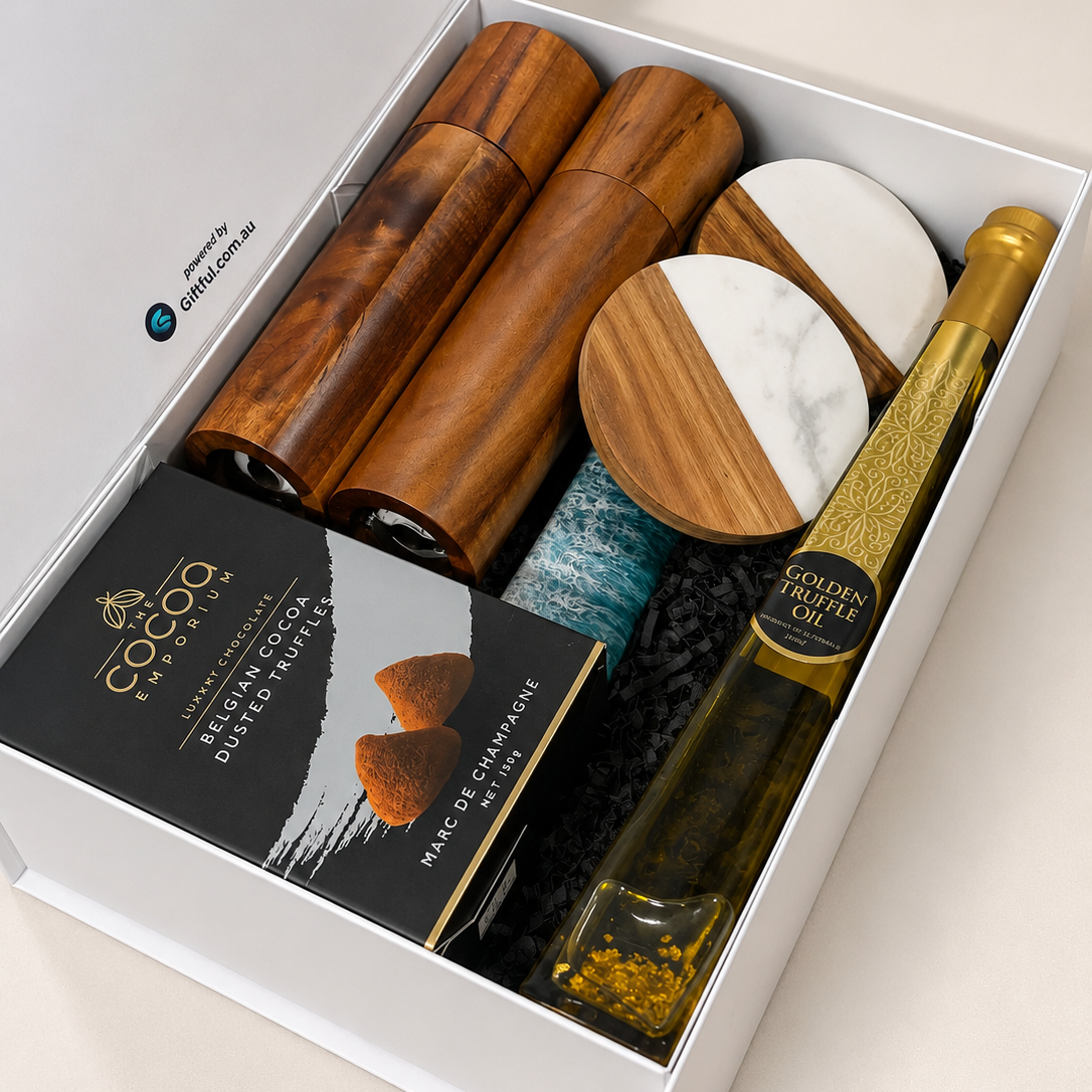 A curated gift box set from Cocco Cosmetics, featuring wooden cosmetic containers, a marble and wood coaster, a bottle of olive oil, and a box of dried apricots, all arranged inside a white box.