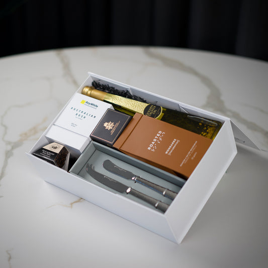 Gift set with cheese tools and chocolate on a marble surface
